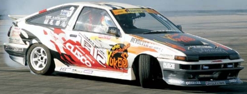 Small white two door Japanese import car modified for drift racing